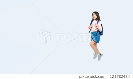 背著背包跳躍的小學生女孩全身照 背著背包跳躍的小學生女孩全身照 125782484