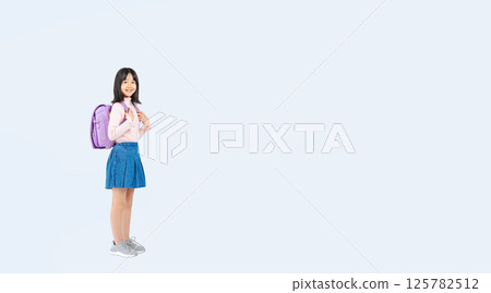 Full-body photo of an elementary school girl carrying a school bag 125782512