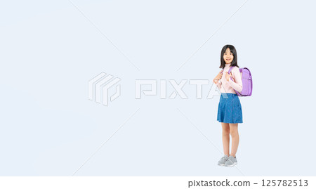 Full-body photo of an elementary school girl carrying a school bag 125782513