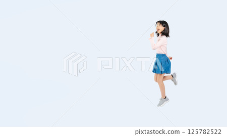 Full body photo of a girl jumping energetically 125782522