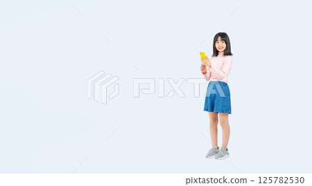 Full-body photo of a girl using a smartphone Full-body photo of a girl using a smartphone 125782530