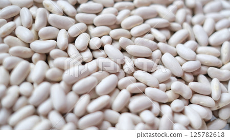 Close-up image of a large pile of white kidney beans, also known as cannellini beans.  125782618