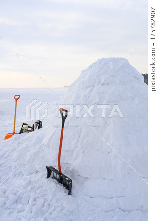 Building an igloo, a national shelter from the cold of the northern peoples, made of snow bricks Building an igloo, a national shelter from the cold of the northern peoples, made of snow bricks 125782907
