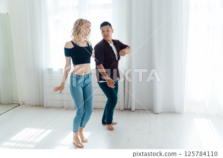 Man and woman dancing together to music 125784110