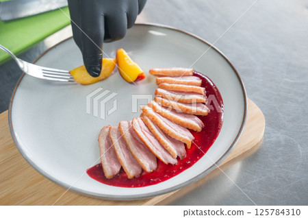 The chef serves roast duck.  125784310