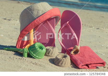 Different shapes made of sand, children toys for playing and accessories for relax on beach Different shapes made of sand, children toys for playing and accessories for relax on beach 125784348