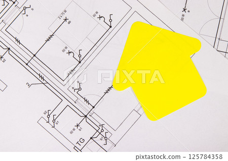 Construction drawing of electric installation, paper in shape of house. Building or buying of home Construction drawing of electric installation, paper in shape of house. Building or buying of home 125784358