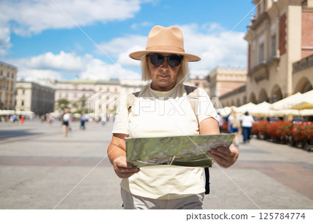 Senior woman exploring the city with a map, sightseeing in the square. 125784774