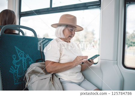 Senior woman using smartphone on a bus while traveling. 125784786