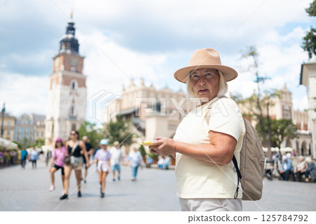 Senior woman exploring the city with a map, sightseeing in the square. 125784792