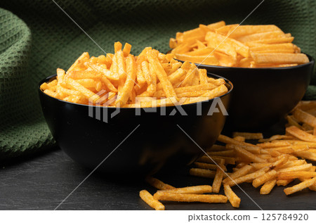 Fried chips sticks, finger potato chips, golden shoestring fries pile, French fries 125784920