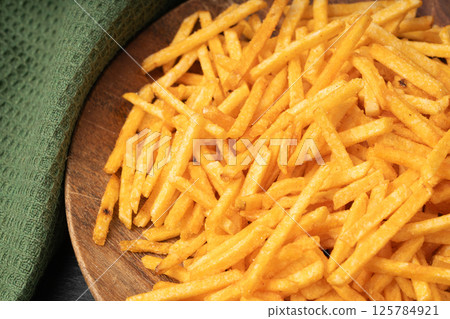 Fried chips sticks, finger potato chips, golden shoestring fries pile, French fries 125784921