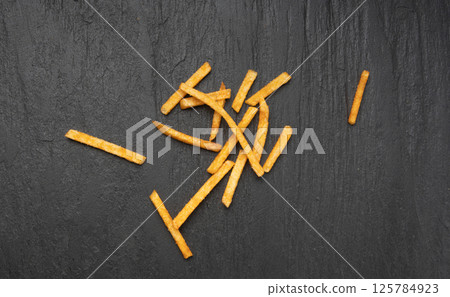 Fried chips sticks, finger potato chips, golden shoestring fries pile, French fries 125784923