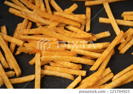 Fried chips sticks, finger potato chips, golden shoestring fries pile, French fries 125784925