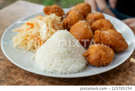 Fried chicken balls with rice and fresh cabbage salad closeup. Deep fried dough balls Fried chicken balls with rice and fresh cabbage salad closeup. Deep fried dough balls 125785154