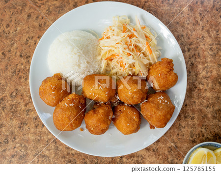 Fried chicken balls with rice and fresh cabbage salad closeup. Deep fried dough balls Fried chicken balls with rice and fresh cabbage salad closeup. Deep fried dough balls 125785155