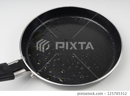 Oil drops on frying pan texture, water splash on black non-stick coating, drop on non stick griddle 125785312