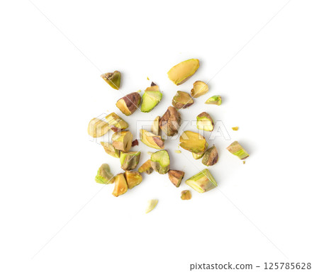 Fried salt pistachio nuts pieces pile isolated. Baked broken pistachios grains, crumbled green pistache 125785628