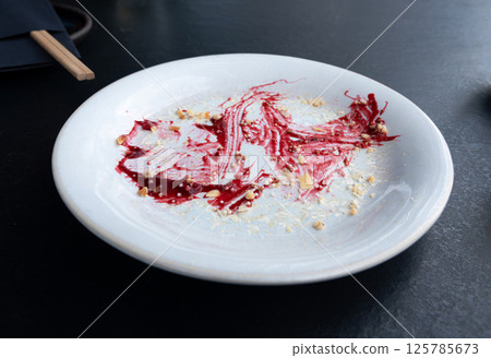 Dirty plate, empty restaurant bowl after dessert, finished lunch, cream and smeared red sauce Dirty plate, empty restaurant bowl after dessert, finished lunch, cream and smeared red sauce 125785673