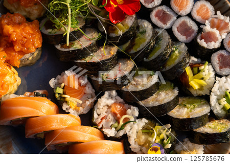 Sushi platter with assorted rolls salmon, tuna, cucumber, avocado, seaweed, rice, tempura Sushi platter with assorted rolls salmon, tuna, cucumber, avocado, seaweed, rice, tempura 125785676