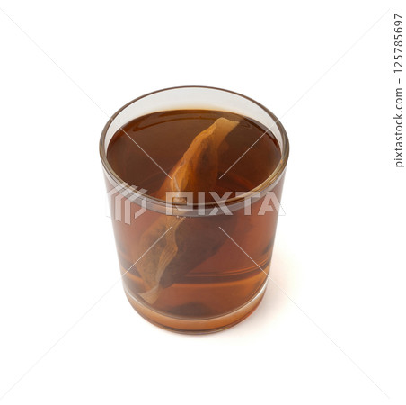 Herbal tea sachet in glass, hot water with chamomile and Hypericum or St. John's wort teabag Herbal tea sachet in glass, hot water with chamomile and Hypericum or St. John's wort teabag 125785697