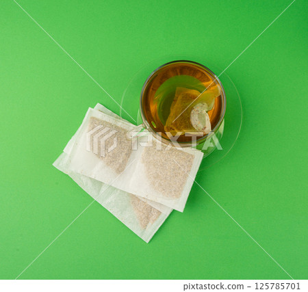 Herbal tea sachet in cup, hot water with chamomile and Hypericum or St. John's wort teabag Herbal tea sachet in cup, hot water with chamomile and Hypericum or St. John's wort teabag 125785701