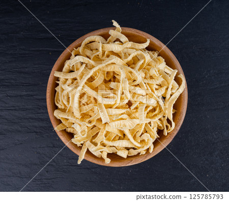 Passatelli spatzle pasta in bowl, raw spaetzle noodles, dry homemade german macaroni 125785793