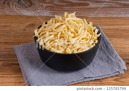 Passatelli spatzle pasta in bowl, raw spaetzle noodles, dry homemade german macaroni 125785799