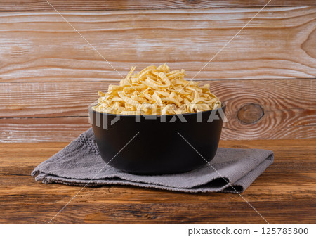 Passatelli spatzle pasta in bowl, raw spaetzle noodles, dry homemade german macaroni 125785800