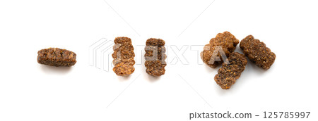 Dry pet food macro pieces isolated, cat kibble closeup, dog pellets, small protein croquettes 125785997