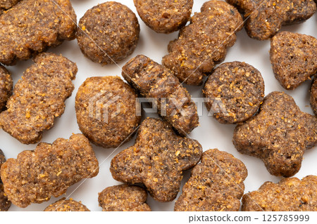 Dry pet food macro pieces, cat kibble closeup, dog pellets, small protein croquettes detailed 125785999