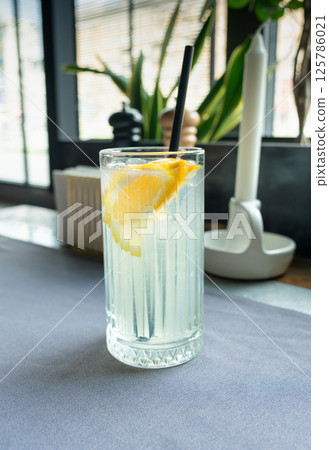 Ice lemonade in tall glass. Yuzu mocktail with lemon and soda, cool lime juice cocktail Ice lemonade in tall glass. Yuzu mocktail with lemon and soda, cool lime juice cocktail 125786021