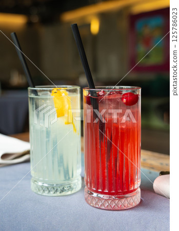 Cold lingonberry drink on restaurant table. Iced cowberry tea, refreshing cranberry cocktail Cold lingonberry drink on restaurant table. Iced cowberry tea, refreshing cranberry cocktail 125786023