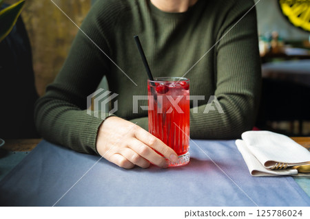 Cold lingonberry drink on restaurant table. Iced cowberry tea, refreshing cranberry cocktail Cold lingonberry drink on restaurant table. Iced cowberry tea, refreshing cranberry cocktail 125786024