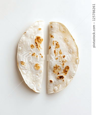 Freshly Cooked Flatbread Halved on a Clean White Background 125786261