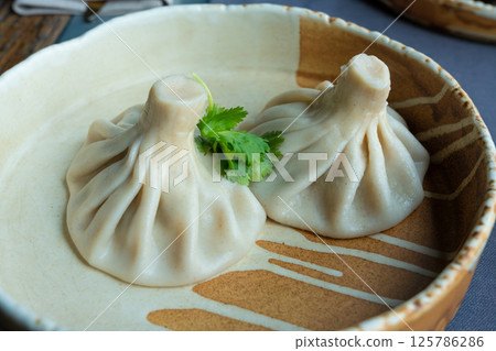 Georgian khinkali or chinkali with minced meat. Traditional spicy Georgian steamed dumplings Georgian khinkali or chinkali with minced meat. Traditional spicy Georgian steamed dumplings 125786286