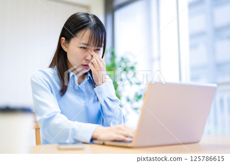 年輕女子在客廳遠距辦公，眼睛疲勞，眼睛疲憊，摀著眼睛，摀著眼角 125786615