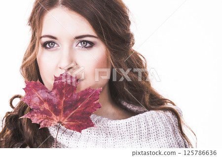 Woman holding maple leaf in hand Woman holding maple leaf in hand 125786636