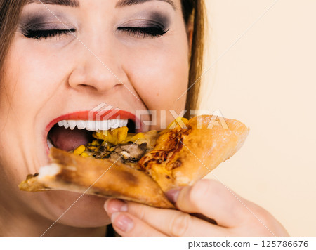 Woman eating hot pizza slice Woman eating hot pizza slice 125786676