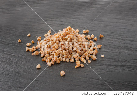 Boiled Buckwheat Pile on Black, Cooked Buck Wheat Grains, Porridge Heap, Cook Buckwheat 125787348