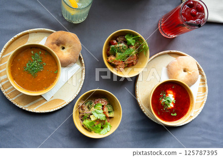 Top view of a traditional lunch with soup, salad, bread, and drinks served on a table Top view of a traditional lunch with soup, salad, bread, and drinks served on a table 125787395