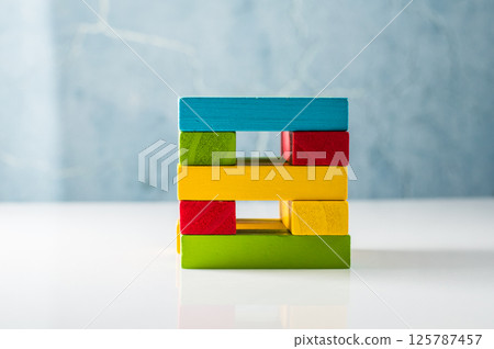 The wooden play blocks are scattered freely, creating a visually interesting composition. Educational wooden toys. 125787457