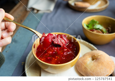 Borscht or borsch in bowl, Ukrainian beetroot soup. Red chowder thick borscht with sour cream Borscht or borsch in bowl, Ukrainian beetroot soup. Red chowder thick borscht with sour cream 125787541