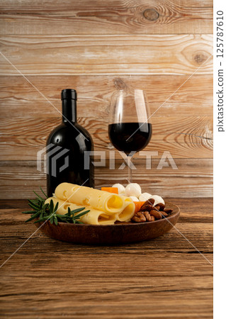 Cheese plate of color cheeses variety, yellow, white and blue gorgonzola platter with red wine glass Cheese plate of color cheeses variety, yellow, white and blue gorgonzola platter with red wine glass 125787610
