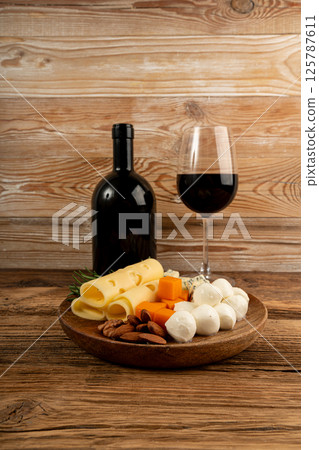 Cheese plate of color cheeses variety, yellow, white and blue gorgonzola platter with red wine glass Cheese plate of color cheeses variety, yellow, white and blue gorgonzola platter with red wine glass 125787611