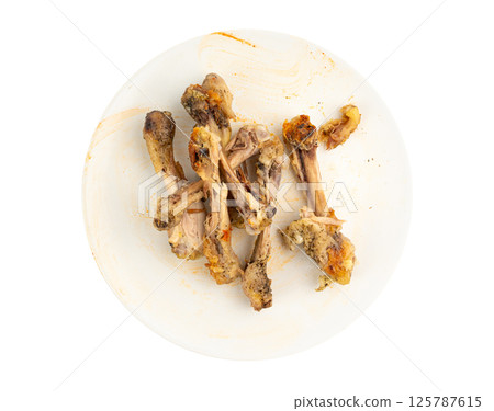 Chicken Leftovers, Unfinished Grilled Chicken on Dirty Plate Isolated, Meat Pieces and Bones after Dinner 125787615