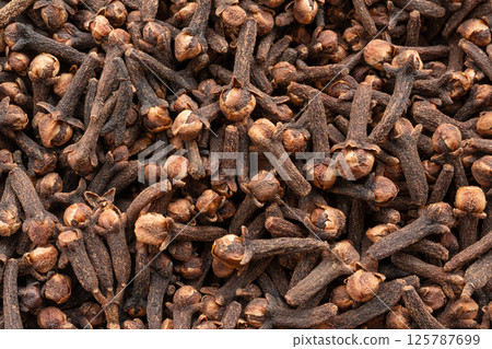 Clove spice textured background. Dry carnation spicy buds pattern, natural Indian clove condiment 125787699
