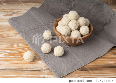 Coconut candies pile, coco ball. White truffle ball, indian ladoo or laddu with sweet cream and coco Coconut candies pile, coco ball. White truffle ball, indian ladoo or laddu with sweet cream and coco 125787707