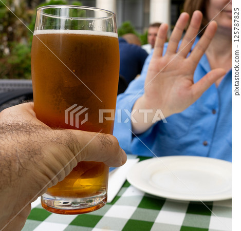 Reject a glass of beer, woman refusing alcohol, stop drinking, sobriety concept, saying no to beer glass Reject a glass of beer, woman refusing alcohol, stop drinking, sobriety concept, saying no to beer glass 125787825