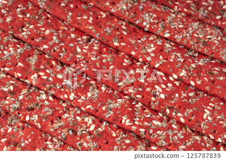 Beetroot crackers, thin rusk beet root bread, red diet multigrain crispbread, various seeds 125787839